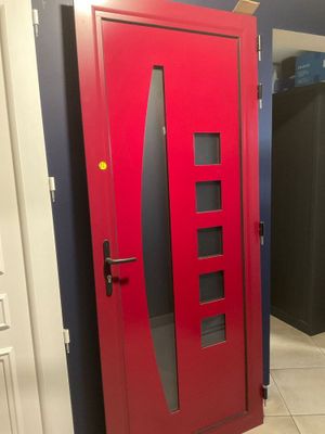 une porte rouge située au milieu d'un couloir