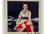 une vieille photo d'une femme en kimono assise sur un rocher
