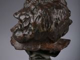 bronze bust of a lion on a pedestal on a gray background