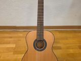 un gros plan d'une guitare posée sur un support, sur un plancher en bois