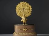 une horloge plaquée or surmontée d'un paon