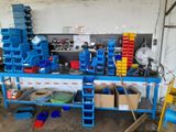 a blue workbench with lots of blue bins on it