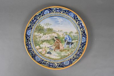 a plate with a painting of a man and a dog on it