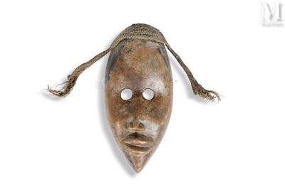une image d'un masque en bois accroché au mur