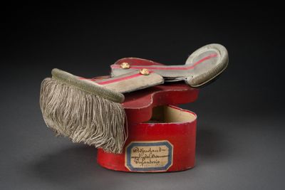 a small red box with a pair of shoes inside of it