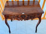 a small wooden table with a drawer on top of it