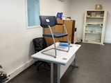 a desk with a chair and a laptop on it in an office