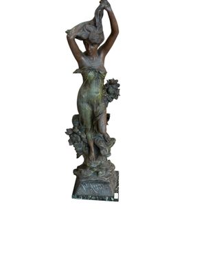 bronze statue of a woman holding a bird on her head