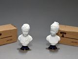 two figurines of a man and a woman are sitting next to a box