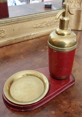 un distributeur de savon et une assiette posés sur une table
