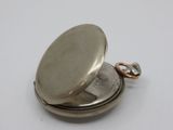 an image of a silver pocket watch on a white surface