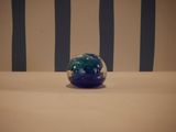 a blue and green glass ball on a white table