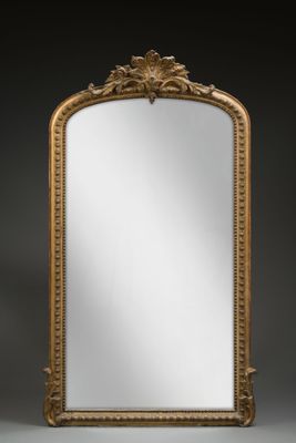 un grand miroir ancien dans un cadre doré