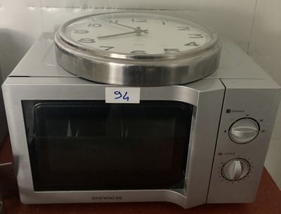 un micro-ondes argenté surmonté d'une horloge
