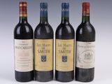 three bottles of red wine are lined up on a white surface