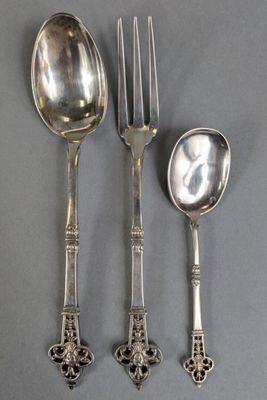 three silver spoons and two silver spoons on a gray surface