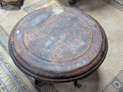 une table ronde avec un plateau en bois posée sur un sol carrelé