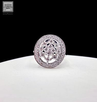 un gros plan d'une bague en diamant posée sur une assiette blanche