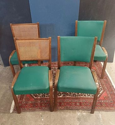 three green chairs with cane back cushions and a rug on the floor