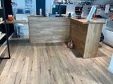 un parquet en bois massif dans un magasin, avec un comptoir et des étagères en arrière-plan