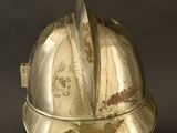 a silver helmet on a stand on a black background