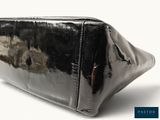 a black purse that is sitting on a white surface