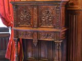 une armoire en bois sur laquelle est posé un vase de fleurs