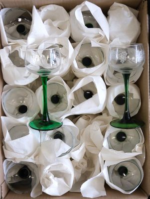 many wine glasses in a box with white napkins