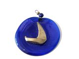 a blue glass ornament with a gold sailboat on it