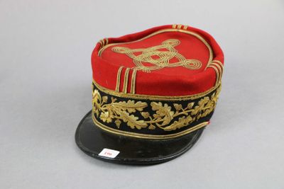 un chapeau rouge et noir orné d'un motif doré