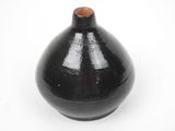 a black vase that is sitting on a white surface