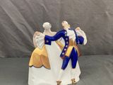 une figurine représentant deux personnes vêtues de bleu et de blanc