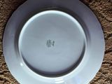 a close up of a white plate on a brown surface