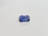 a blue sapphire stone on a white surface