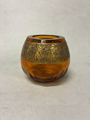un petit vase en verre orné d'un motif doré