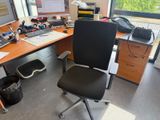 un bureau avec un ordinateur et une chaise devant une fenêtre