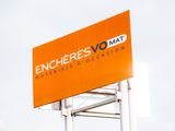 un panneau orange sur lequel est écrit « encheres vomat »