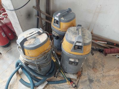 three wet vacuums sitting on the floor next to each other