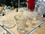 des bouteilles et des verres posés sur une table dans un magasin, avec un objet rouge en arrière-plan