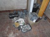 a pile of trash on the floor next to a pipe
