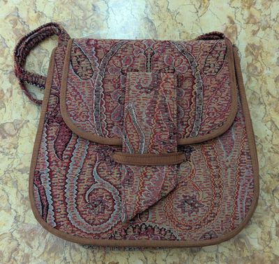 le sac à main est posé par terre, sur le sol en marbre