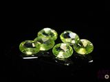 a group of green gems sitting on top of a black surface