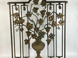 an image of a metal screen with a vase and leaves on it