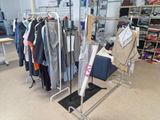 a rack of clothes in a clothing store with clothes hanging on it