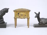 deux statues d'animaux en bronze et une table sur laquelle se trouve une horloge