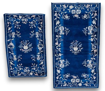 a pair of blue and white rugs with floral designs