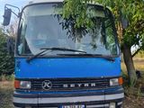un bus bleu garé à côté d'un arbre