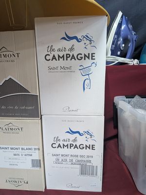 plusieurs cartons de vin posés sur une table à côté d'une table à repasser
