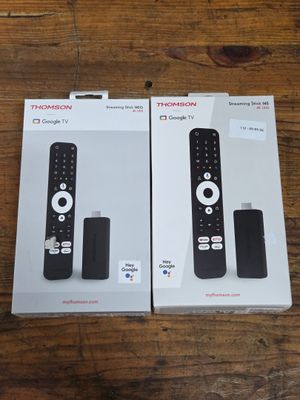 two boxes of remote controls sitting on a wooden table
