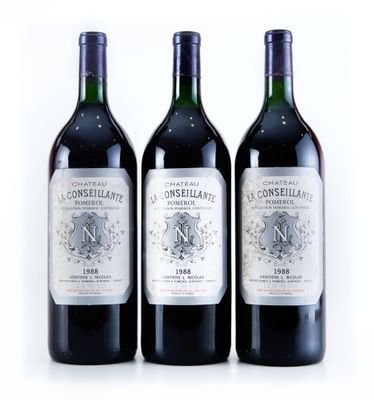 trois bouteilles de vin sont alignées sur une surface blanche